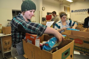 a volunteer sorts through donated food in a box