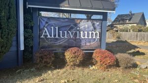 alluvium church purple banner outside the church; low red bushes and green grass